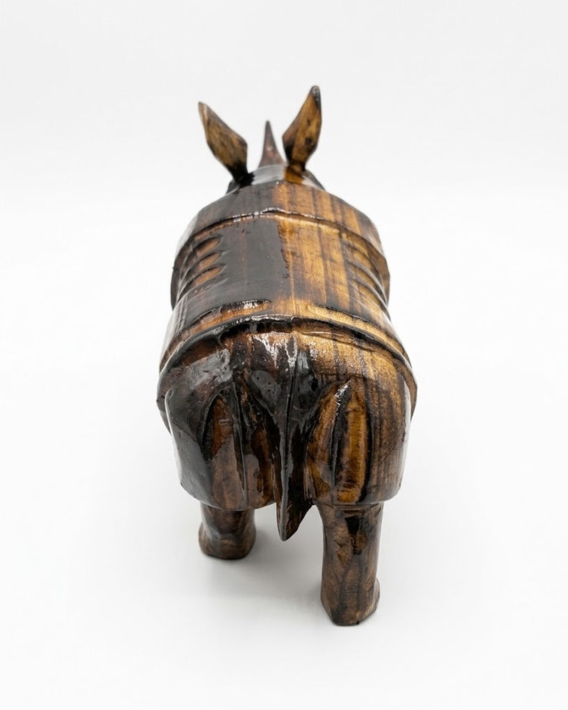 The rhinoceros from behind and above on a pale ground: the ridged plates across the back and rump, and the two ears raised.