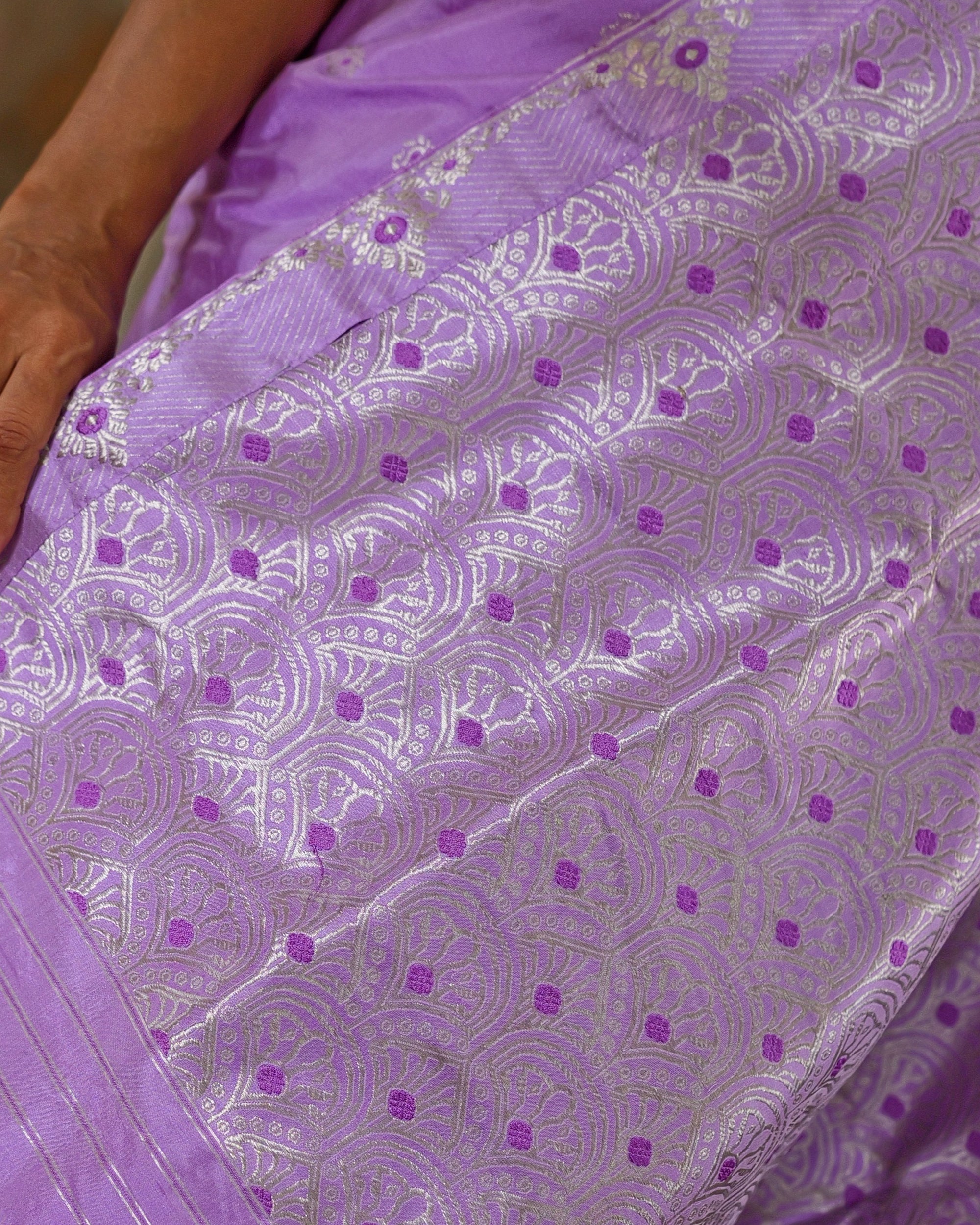 The pallu close up. Overlapping silver arches like fish scales, each outlined in fine concentric lines and centred on a violet square.