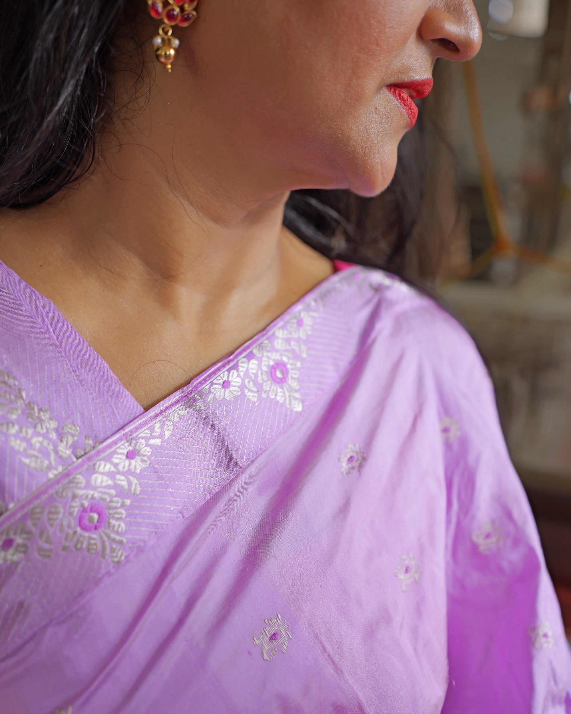 The drape across the shoulder, a silver floral band running along its edge.