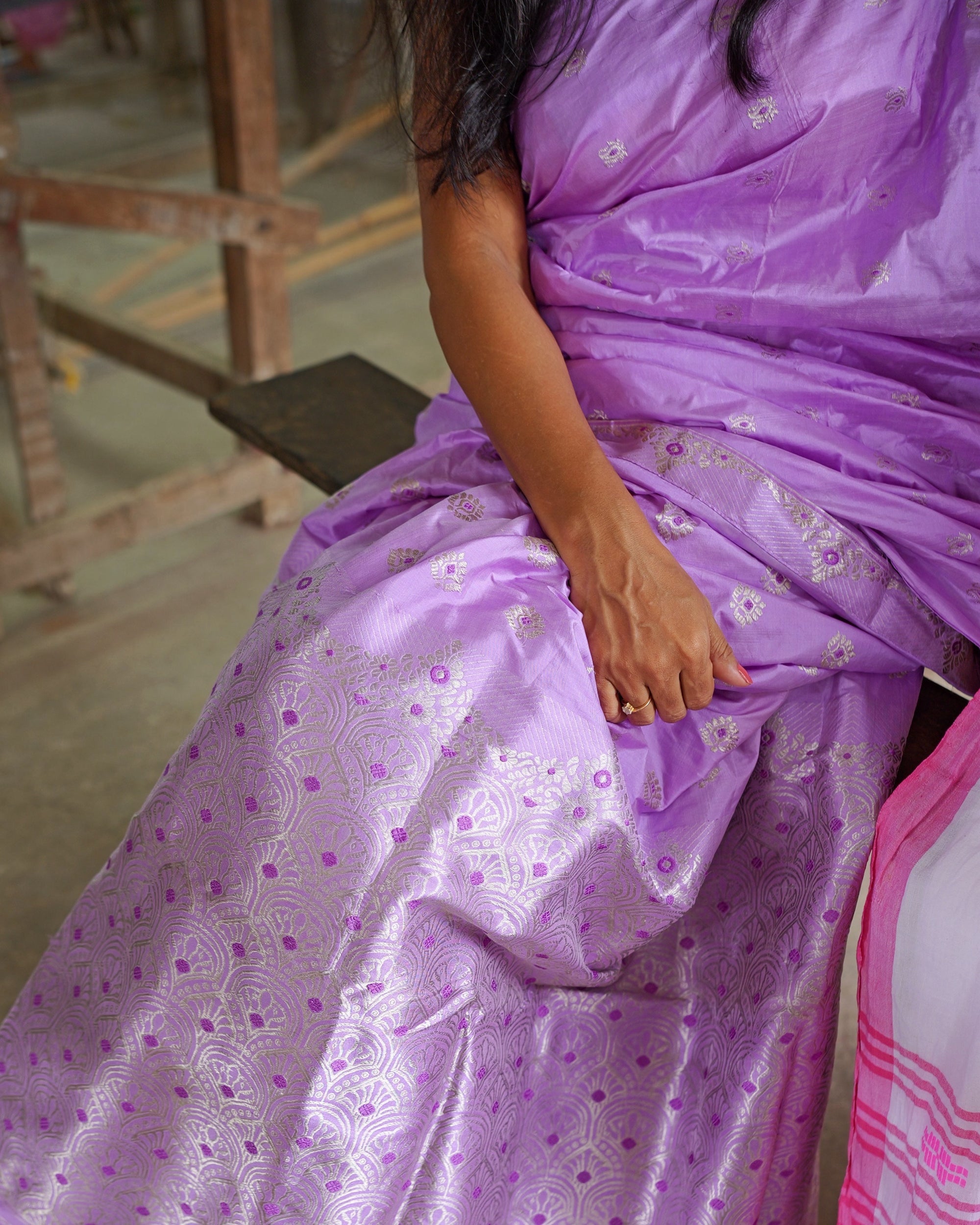 The lower drape across the lap, silver rosettes on the body above the arched field.