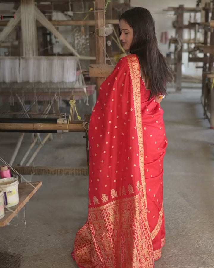 Turning slowly between the handlooms in the red saree, the pallu held out and then falling down the back in gold.