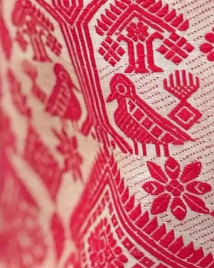 A slow pass across the red pallu: pairs of birds, trees and eight-petal rosettes on gold.