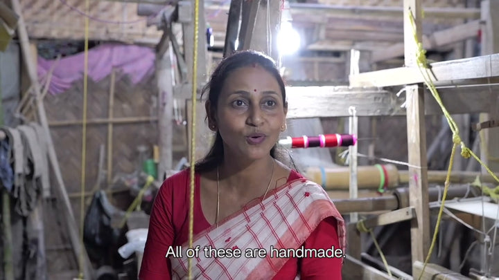 Deepa Kakoty in her loom shed in Sualkuchi, saying how much careful hand work goes into what she weaves, with English subtitles. It opens on Sualkuchi's welcome gate. 9 seconds.