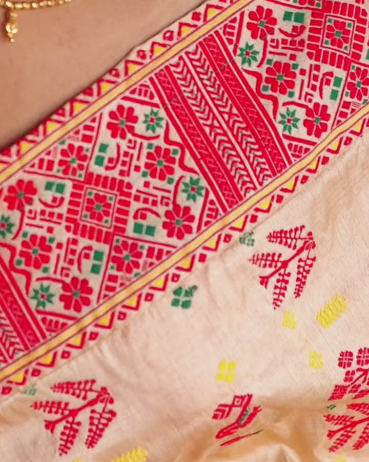 Fingertips running along the wide red border across the chest: rosettes, green stars and chevron bands.