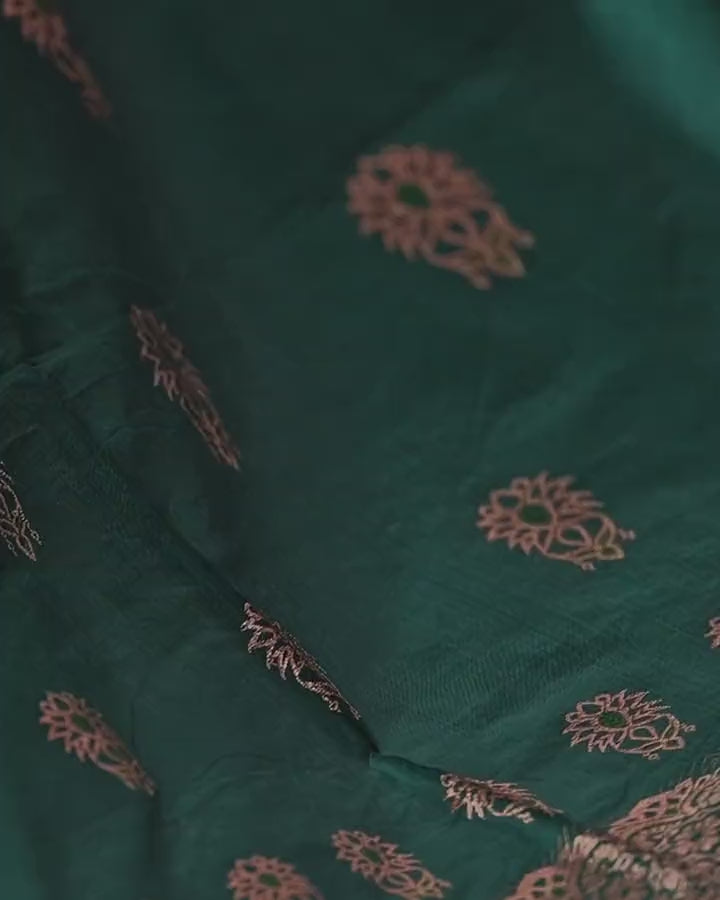 The green body of the sador moving gently, scattered with copper-gold flower motifs.